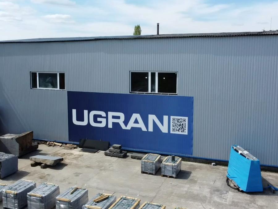 UGRAN plant yard from above: the workshop with its banner and rows of packed pallets